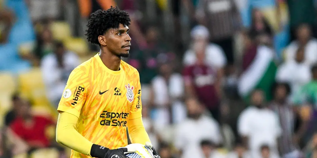 Goleiro Hugo Souza, um dos destaques entre os jogadores do Corinthians na seleção, veste o uniforme amarelo de treino do clube enquanto segura a bola durante uma partida oficial.