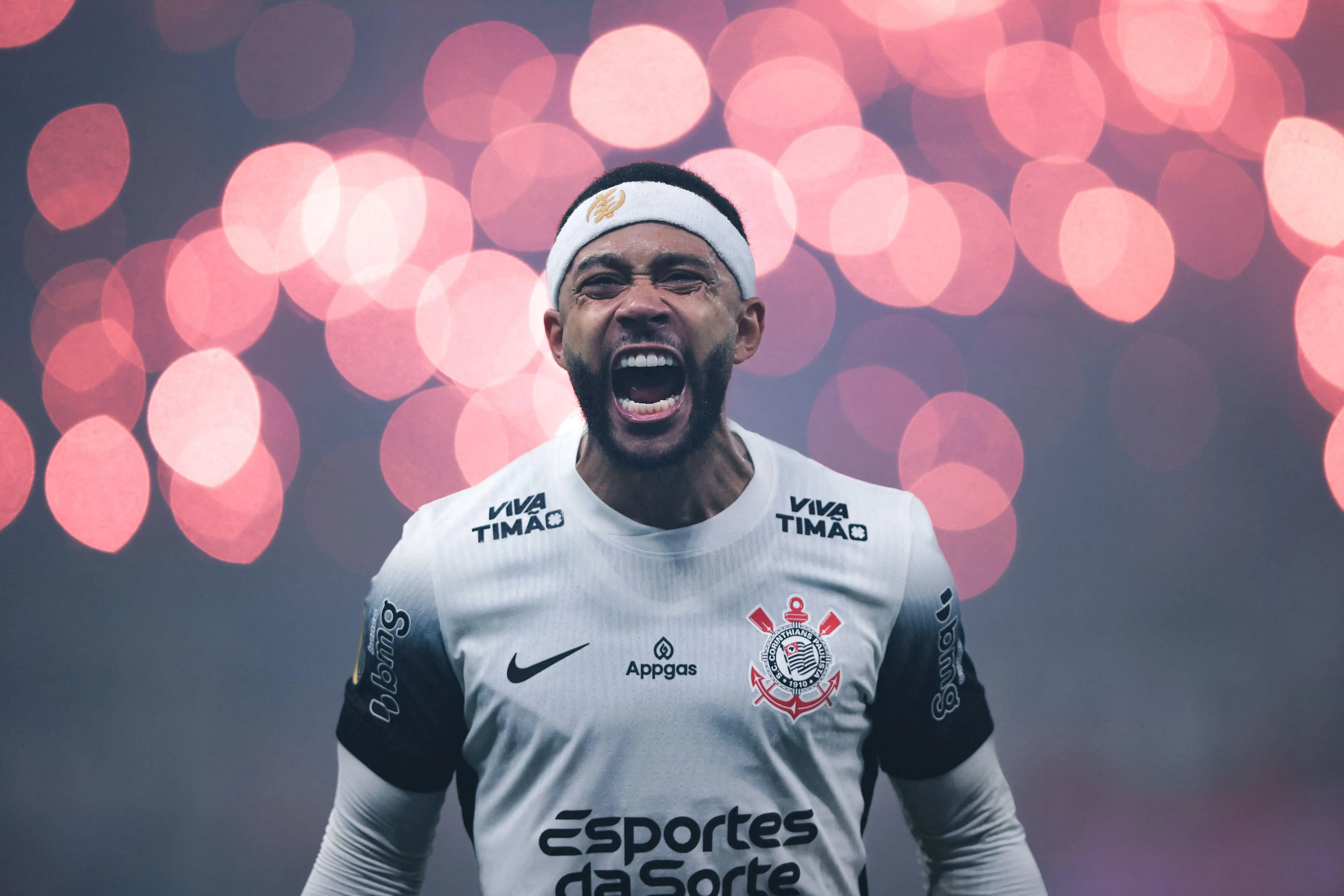 Memphis Depay no Corinthians visto de costas, com tranças e faixa branca na cabeça, usando a camisa alvinegra durante uma partida.